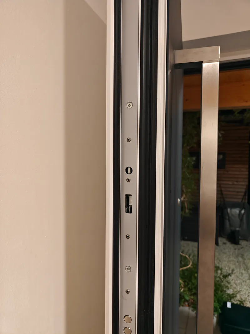 Türkante einer Aluminium-Haustür mit Schlossstulp, Zylinderausschnitt und Riegel
