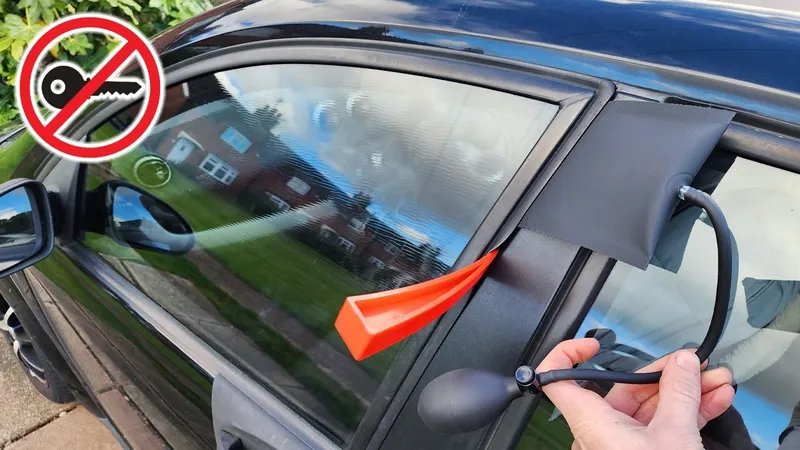 Autotür wird mit Keil und Pumpkissen angehoben, eine Hand bedient den Blasebalg
